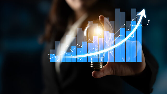 A professional holding a light bulb symbolizing innovation against a backdrop of a growing data graph, signifying business success and creative growth strategies. Scalp