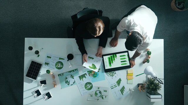 Top down view of business man presenting sustainable idea to manager by using tablet display ESG environmental social governance. Manager working together planning to use clean energy. Alimentation.