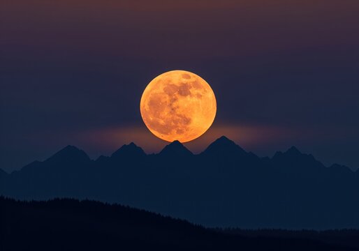 Dramatic orange supermoon rising over dark mountain peaks during twilight hours.