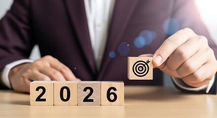 Businessman in a suit places a wooden block with a target symbol on top of blocks spelling out 2026, symbolizing future goals and success background image