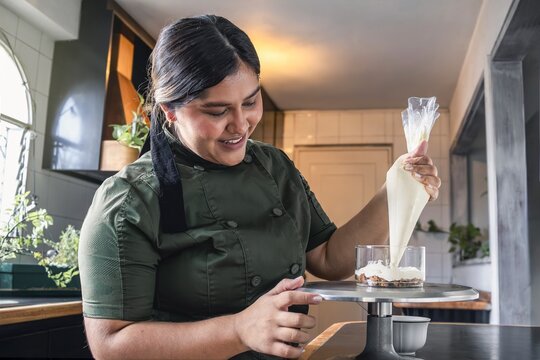 Pastry chef making dessert with piping bag
