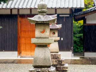 雨に濡れた神社の石灯籠