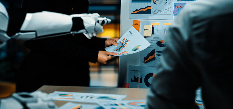 A modern office setting highlights a robotic arm assisting in a business meeting by presenting data visualizations to a professional team, emphasizing innovation and collaboration.Noogenesis