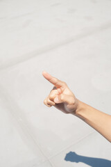 A person's hand with extended index finger pointing upwards, casting a shadow.