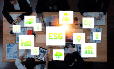 Business professionals discuss ESG concepts while analyzing data in a collaborative workspace, emphasizing sustainable development and corporate responsibility efforts. Trope