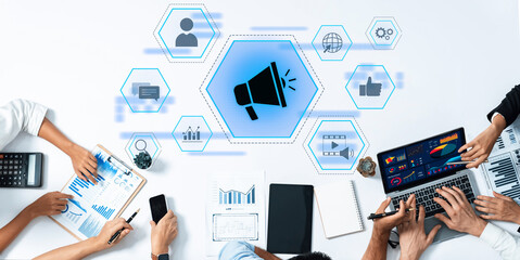 A modern business meeting featuring diverse team members analyzing data visuals on digital devices, focusing on innovative marketing strategies and collaboration in a workplace setting. Trope