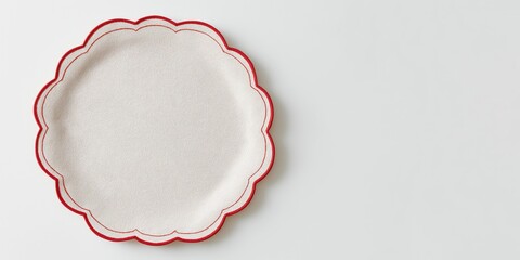 a minimalist scalloped linen placemat with red piping border on a white background.