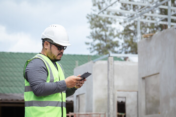 Asian overweight construction project foreman wearing white hard hat and reflective safety vest...
