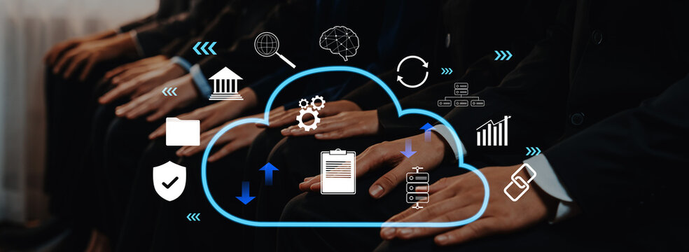 Group of business professionals in a modern office setting engaged in a discussion about cloud computing technology, showcasing various data and analytics icons. Trope - Powered by Adobe