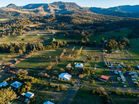Train line and farmland at sunset with long shadows in Murrirundi seen from aerial view