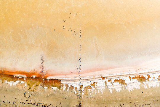 Stranded fence remnants cutting through a salt-crusted lake bed.