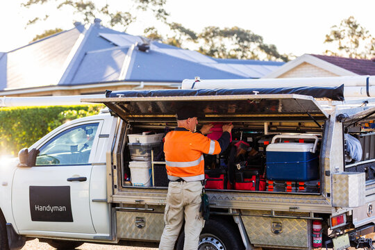 Middle aged man replacing tool in handyman ute