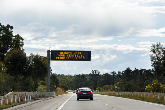 overhead digital sign on highway with text - always wear your seatbelt penalties apply