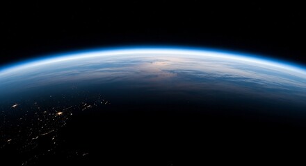 Obraz premium Earth's horizon seen from space, showing the curvature of the planet, the atmosphere, and city lights at night.