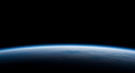 Earth's horizon glows with a soft blue atmospheric haze against the blackness of space, showcasing the planet's curvature.