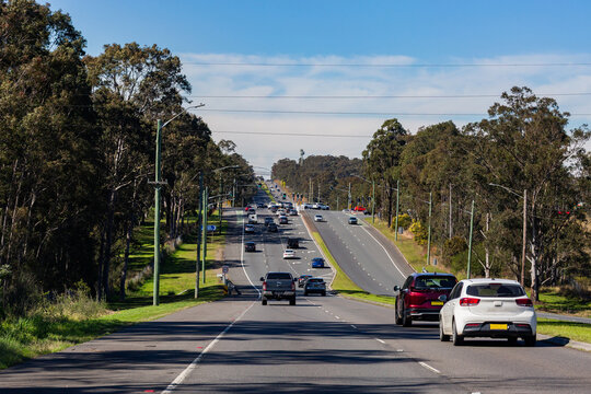 traffic passing along road with lanes and traffic lights at intersection