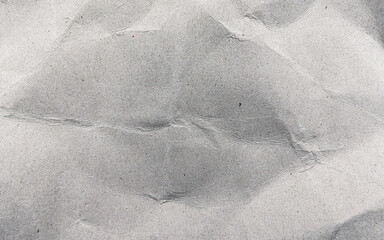 Close-up of wrinkled recycled grey cardboard surface with natural creases and folds. Perfect for eco design, packaging texture, or realistic recycled paper backgrounds.