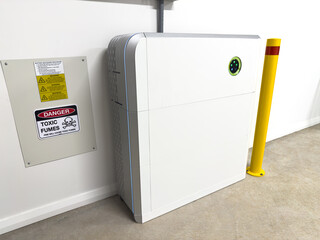 Solar electric battery storage unit in a garage with blue light indicating charge level