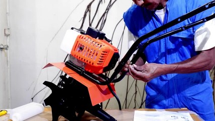 Inspecting the parts of the newly purchased online hand tractor by an elderly farmer at home