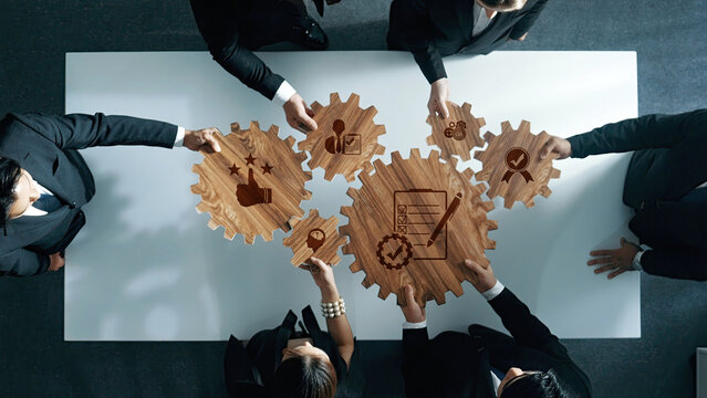 A dynamic scene showcasing colleagues collaborating in a modern office, using wooden gears to symbolize teamwork and strategic planning, highlighting communication and innovation. Amity