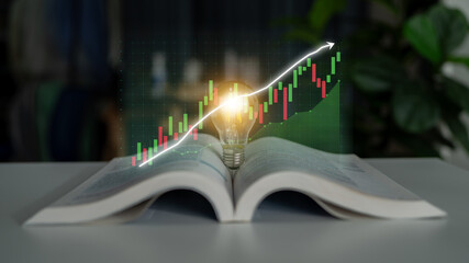 An open book with a glowing light bulb at its center showcases a digital stock chart, representing...