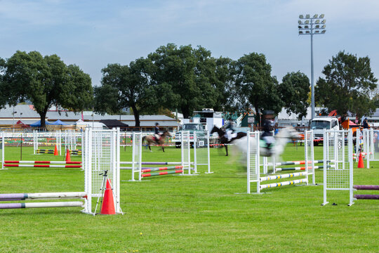 blurred motion of anonymous event rider competing in showjumping at local showground