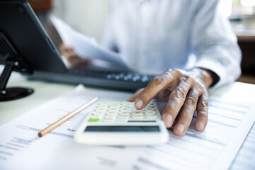 close up shot, accountant calculate business costs, profits and tax working with tablet on desk in...