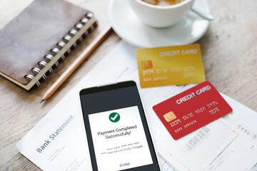 smart phone with payment successful notification on screen with credit card and bill of expenses, bank statement, online shopping concept and paying