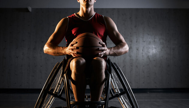Determined male athlete in a sports wheelchair holding a basketball ready to play.