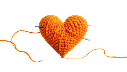Knitted orange yarn heart impaled by needles against dark