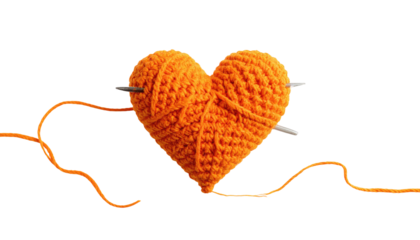 Knitted orange yarn heart impaled by needles against dark