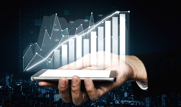 A hand presents a smartphone displaying a graph visualization that indicates business growth and progress. The backdrop features a sophisticated cityscape, highlighting modern technology. Impute