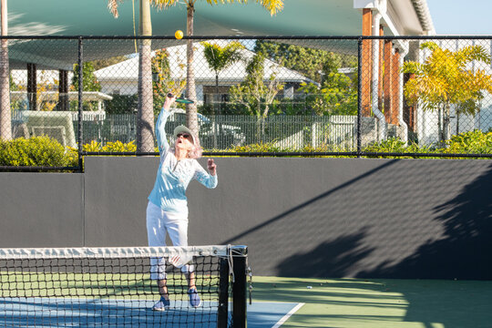 active senior woman playing pickleball outdoors