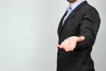 a modern businessman at the right side of the screen ready to hold something with his hand and a white background