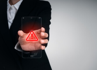 Businessperson holding a futuristic transparent smartphone with red warning symbol, representing scam alert, mobile virus, cybersecurity threat, and future phone technology risk awareness concept.