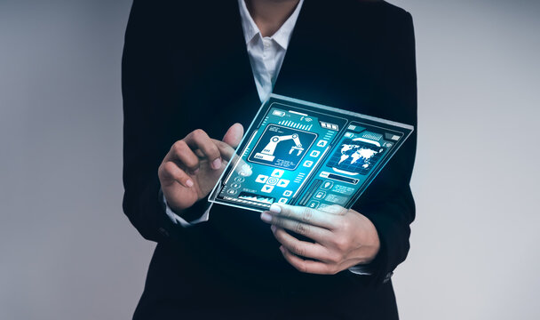 Businessman using transparent futuristic tablet with robotic control dashboard, symbolizing robotics engineering, smart automation, high-tech interface, and future technology in industrial innovation.