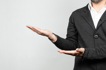 a modern businessman at the right of the screen ready to showing a product with his hands and a white background