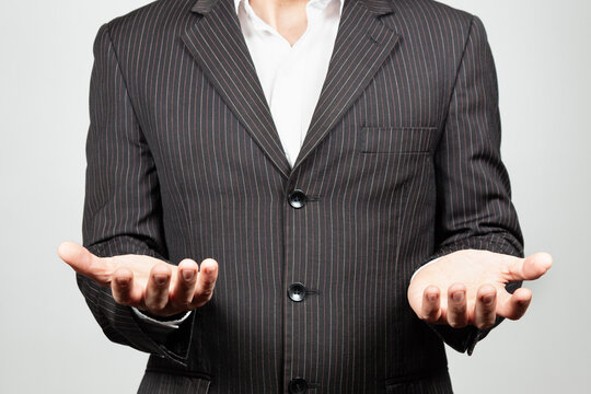 a businessman on suit with his both hands in front of him ready to hold something - Powered by Adobe