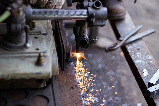 Oxy-fuel metal cutting with bright sparks in workshop