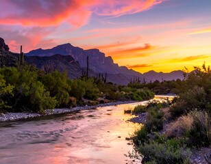 Sunset over a desert river with mountains, cacti, and colorful sky