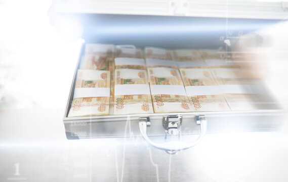 A metal suitcase filled with Russian banknotes of 5000 rubles. Double exposure. Investment, bribe, corruption concept.