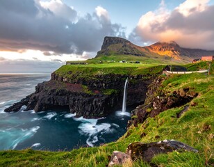 Stunning coastal landscape featuring a cascading waterfall, rugged cliffs, vibrant green vegetation, and a dramatic cloudy sky at sunset