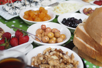 Delicious spread of fruits and snacks on a green tablecloth