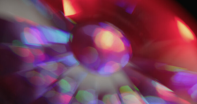Glow ball bokeh. Leak illumination. Neon color glass sphere kaleidoscope rotation on black. Red purple ray abstract blur background.