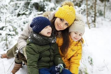 Fototapeta premium Happy family playing and laughing in winter outdoors in the snow. City park winter day.