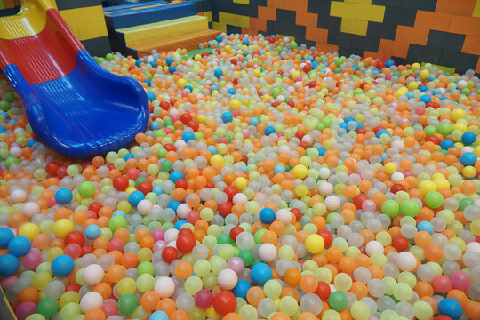 Colorful play area filled with ball pit and slide for kids