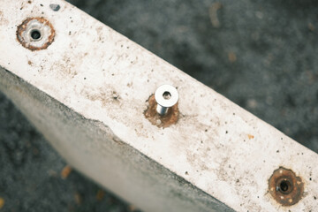 Screw inserted into a concrete element, close-up of building material and connection