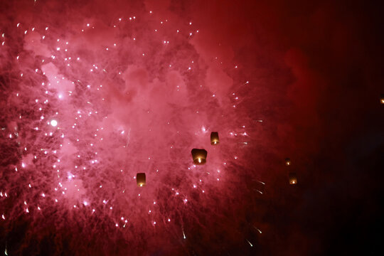 Magical red firework explosion in night sky. Glowing lanterns float during beautiful festival celebration, creating dramatic burst of vibrant light and hope - Powered by Adobe