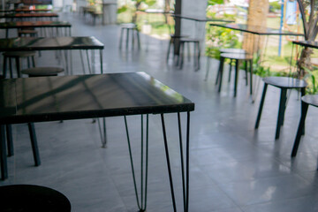 Sleek Black Tables and Stools Await Customers in an Open air Setting