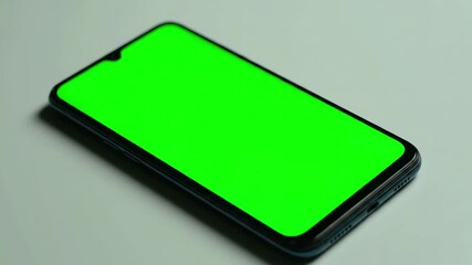 Technology & Innovation with male cryptocurrency trader investor analyst hand holding cell phone green mockup screen doing stock market data price graphs analysis using trading mobile app application - Powered by Adobe